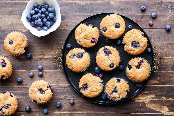 Muffins topped with blueberry in a plate and on top of the table