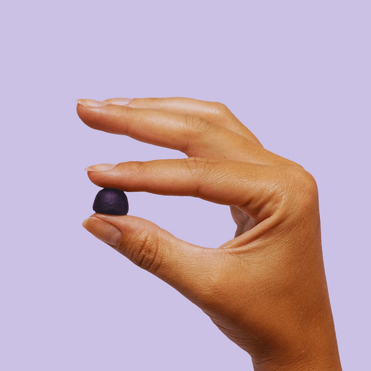 a hand holding a gummy